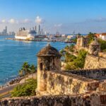 Escena ilustrativa de una bahía caribeña con murallas y un crucero, inspirada en Cartagena