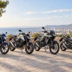 Honda CB125F, CB750 Hornet, XL750 Transalp y Forza 750 aparcadas junto a una ciudad mediterránea